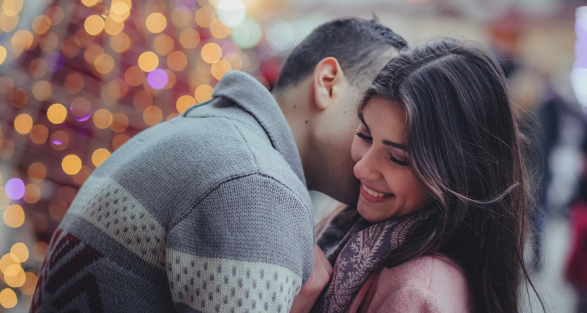 Un couple partage un moment tendre et complice devant des lumi&egrave;res scintillantes