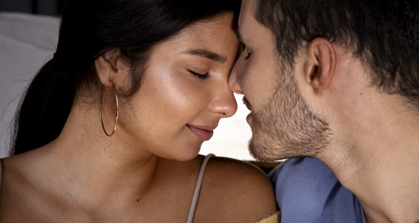 Couple partageant un instant romantique et intime dans une chambre cosy