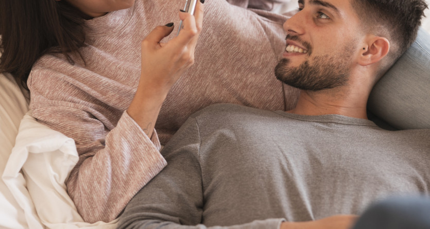 Couple souriant partageant un moment complice dans une chambre avec jacuzzi privatif