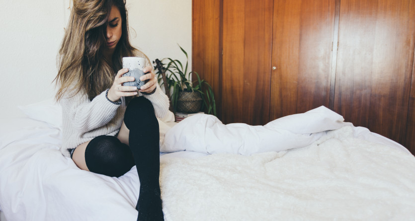 Femme profitant d'un moment de d&eacute;tente avec une tasse dans une chambre confortable