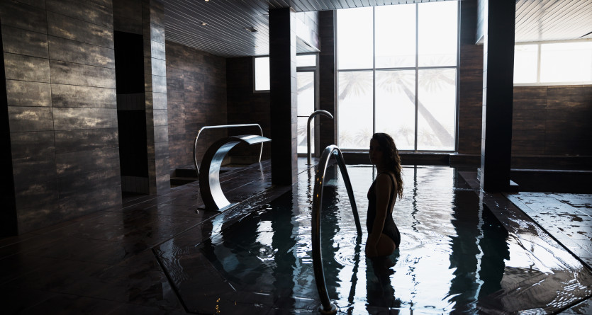 Femme debout dans un spa priv&eacute; avec un design moderne et ambiance tamis&eacute;e