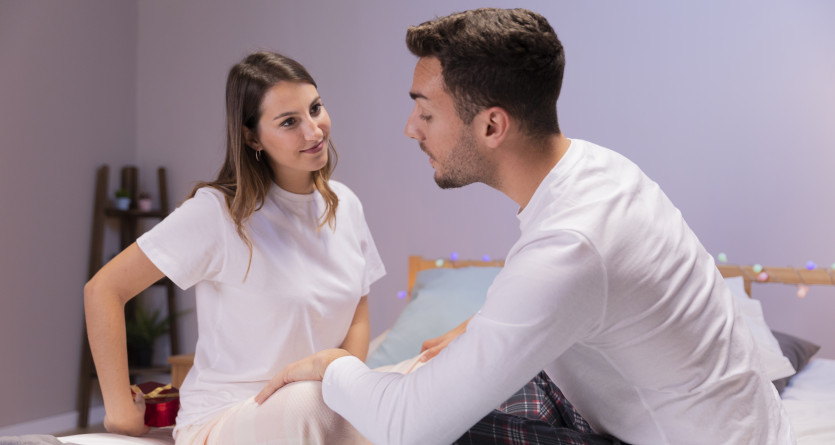 Un couple partageant un moment complice dans une chambre chaleureuse, id&eacute;al pour une escapade romantique.