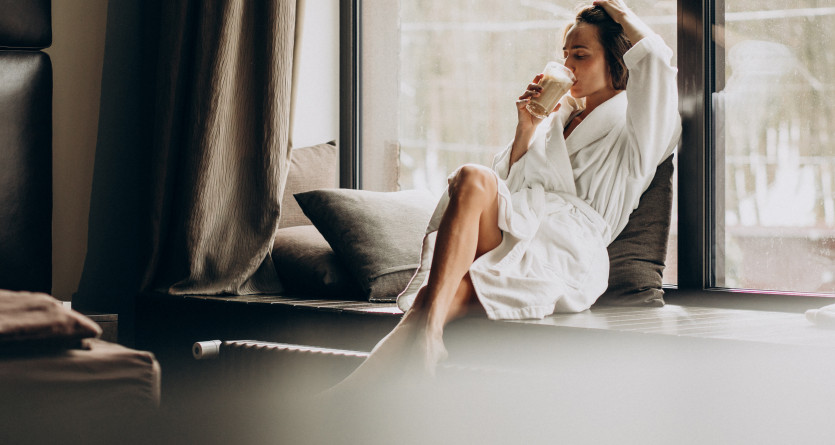 Femme en peignoir savourant une boisson chaude pr&egrave;s d&rsquo;une fen&ecirc;tre dans une Secret Room