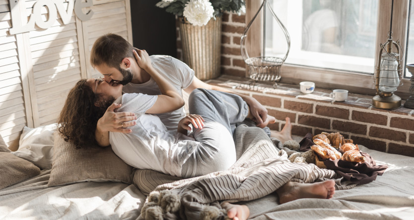 Un couple partage un moment tendre et romantique dans une Love Room, entour&eacute; de d&eacute;tails chaleureux.