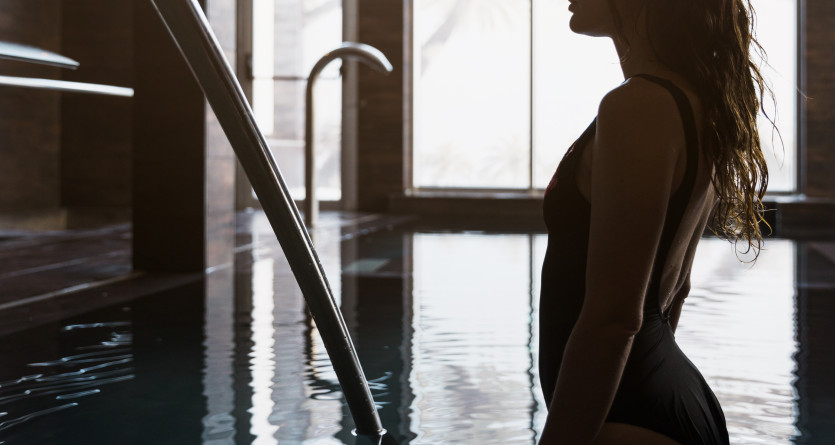 Une femme dans une piscine privative, profitant d&rsquo;un moment de calme et d&rsquo;intimit&eacute; dans une ambiance tamis&eacute;e