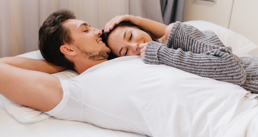 Un couple partage un moment de tendresse et de complicit&eacute; dans une chambre romantique