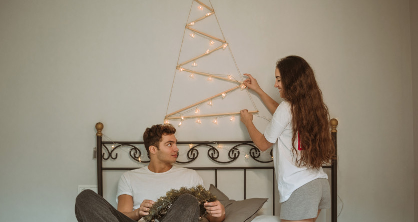 Couple d&eacute;corant une chambre avec des lumi&egrave;res festives, parfait pour une escapade romantique en Secret Room