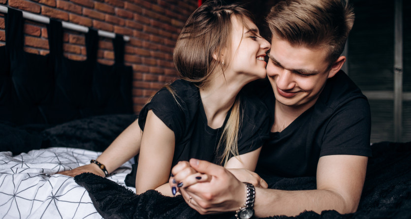 Un couple partage un moment complice et romantique dans une chambre &eacute;l&eacute;gante