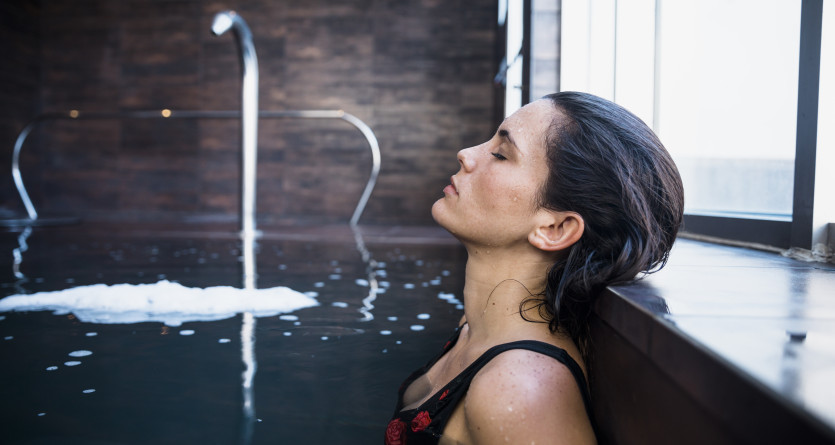 Femme relaxant dans un jacuzzi privatif avec une ambiance luxueuse et intime