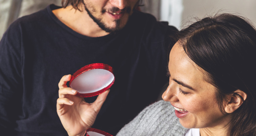 Un couple partage un moment romantique en d&eacute;couvrant un cadeau dans un cadre intime et chaleureux