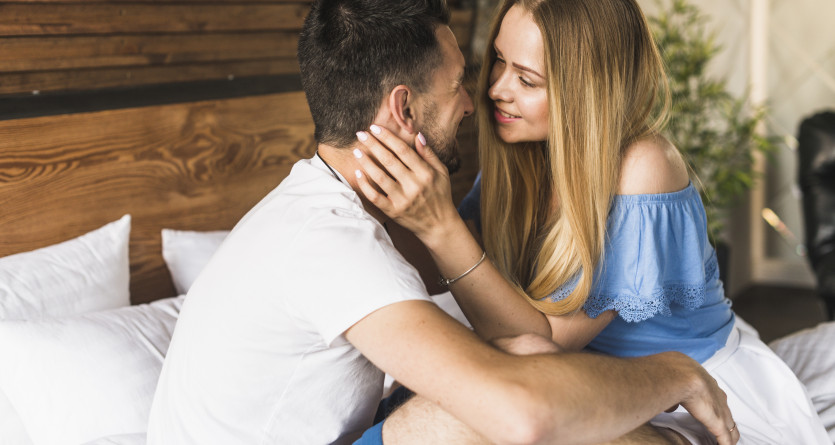 Un couple partage un moment de complicit&eacute; et de tendresse dans une chambre moderne et chaleureuse, parfaite pour une escapade romantique