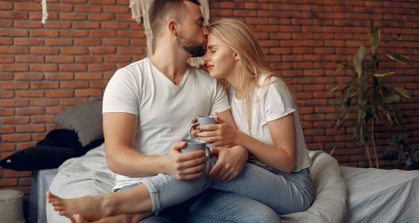 Un couple partage un moment tendre et complice en buvant un caf&eacute; dans une chambre cosy avec un mur en briques