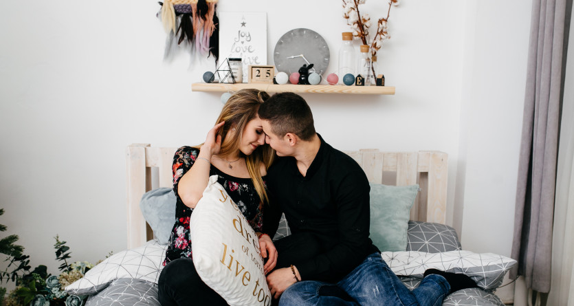 Un couple complice partage un moment tendre dans une chambre d&eacute;cor&eacute;e avec soin, id&eacute;ale pour une Secret Room romantique.