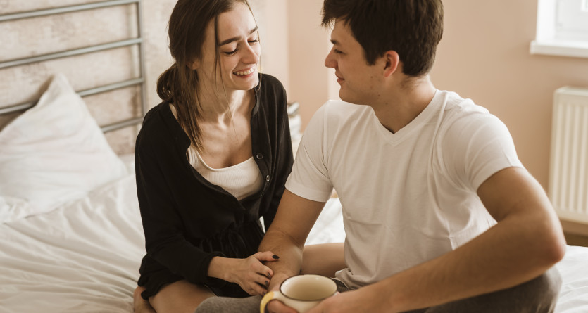Un couple complice partage un moment chaleureux avec une tasse de caf&eacute; dans une Love Room cosy.