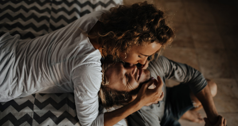 Couple partageant un moment intime et complice dans une chambre cosy, parfait pour une Secret Room romantique