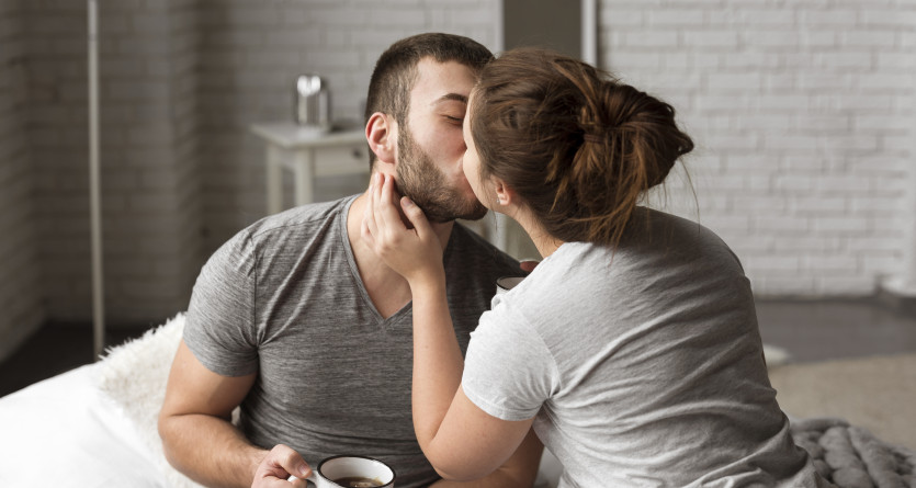 Un couple s&rsquo;embrasse tendrement dans une chambre &agrave; l'ambiance cosy avec jacuzzi privatif