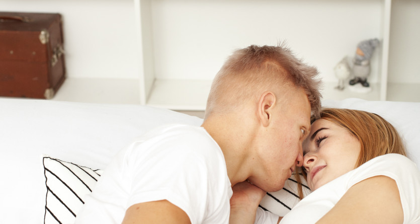 Un couple allong&eacute; sur un lit dans une ambiance intime et romantique