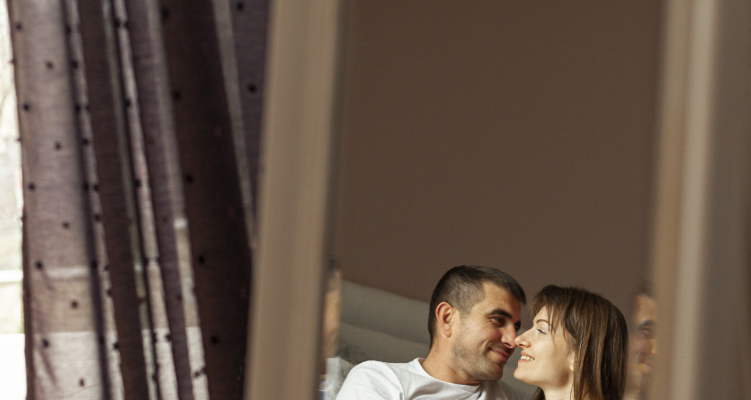 Couple complice refl&eacute;t&eacute; dans un miroir d&rsquo;une Love Room sensuelle