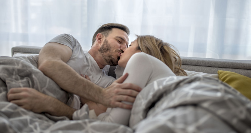 Couple s&rsquo;embrassant tendrement sous une couverture, symbole de romantisme et de complicit&eacute; en Secret Room