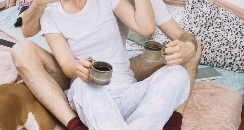 Couple s&rsquo;embrassant tendrement sur un lit avec une tasse de caf&eacute;, symbole d&rsquo;intimit&eacute; et de bien-&ecirc;tre en Secret Room