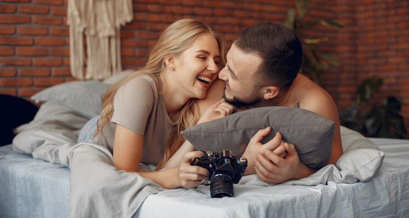 Couple souriant et complice dans une Love Room cosy et romantique