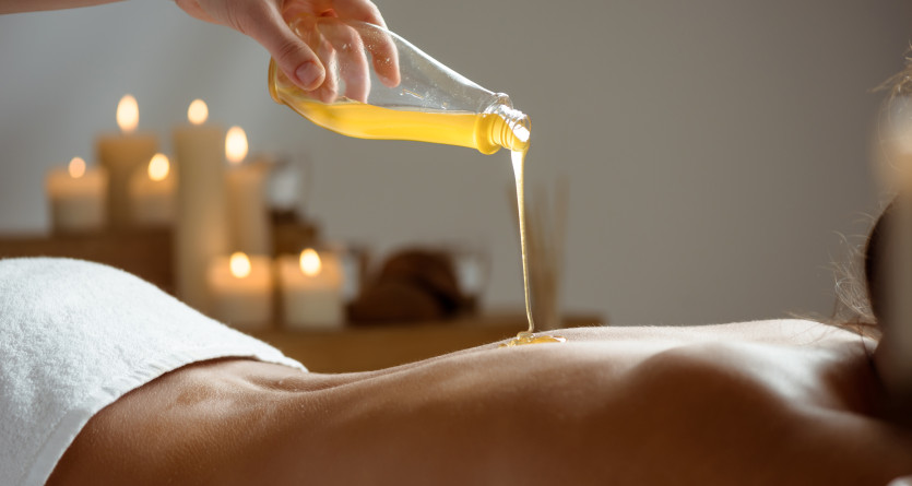 Huile vers&eacute;e pour un massage relaxant dans une chambre de luxe