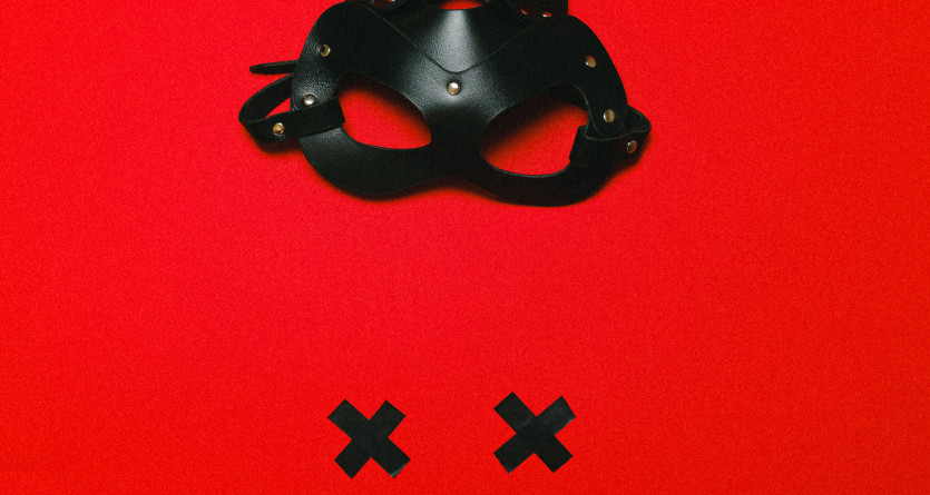 Masque &eacute;nigmatique sur fond rouge, invitation &agrave; l'inconnu