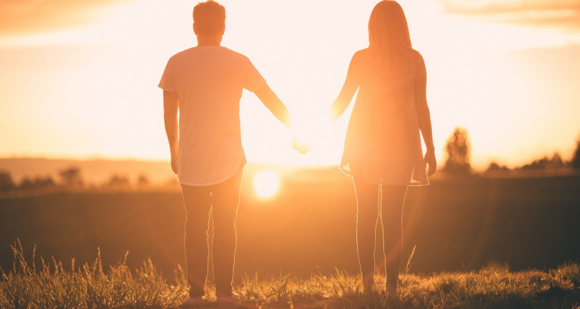 Couple main dans la main face au coucher de soleil, pure romance