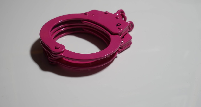 Menottes roses sur fond blanc, &eacute;voquant un jeu s&eacute;duisant en chambre de luxe