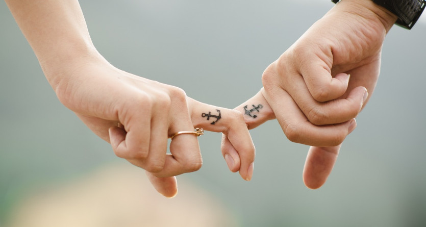 Mains li&eacute;es par le petit doigt, tatouages symbolisant un lien &eacute;ternel