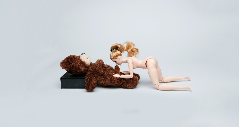 Poup&eacute;e et peluche dans une mise en sc&egrave;ne tendre, allusion &agrave; la douceur d'une 'Love Room'