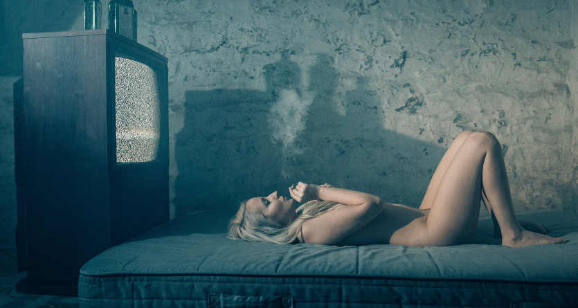 Femme allong&eacute;e dans une pi&egrave;ce d&eacute;labr&eacute;e, contraste avec l'id&eacute;e d'une 'Love Room'