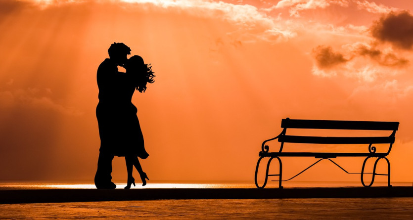 Silhouette d'un couple dansant au coucher du soleil, symbolique d'une 'Love Room'