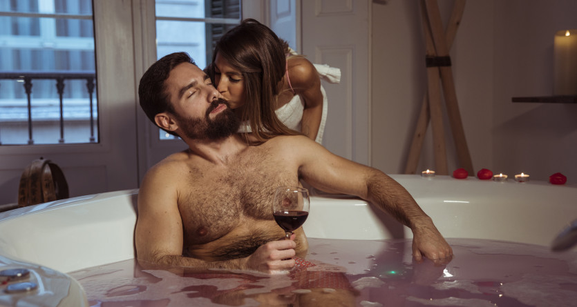 Couple en moment intime dans une chambre avec jacuzzi privatif, &eacute;voquant luxe et romance