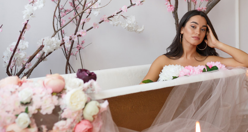 Femme entour&eacute;e de fleurs et de bougies dans une baignoire, ambiance florale