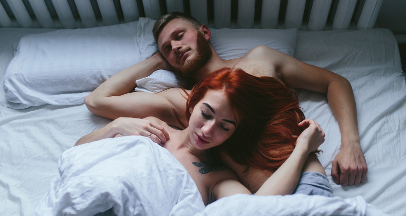Couple en peignoirs partageant un moment joyeux dans leur chambre d'h&ocirc;tel luxueuse