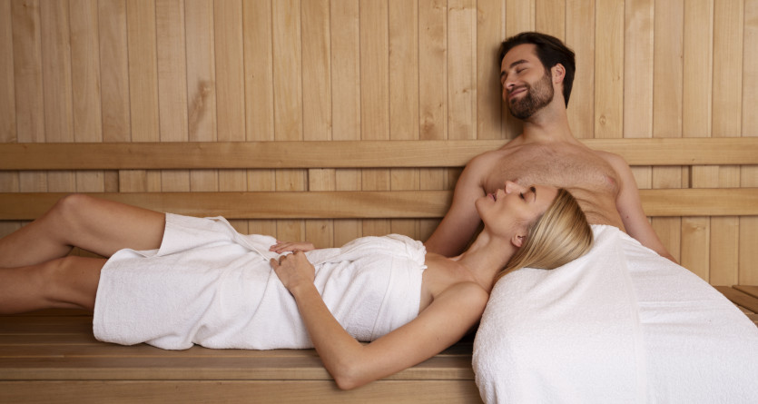 Couple enlac&eacute; dans un drap blanc, exprimant l'intimit&eacute; dans une chambre lumineuse et &eacute;pur&eacute;e