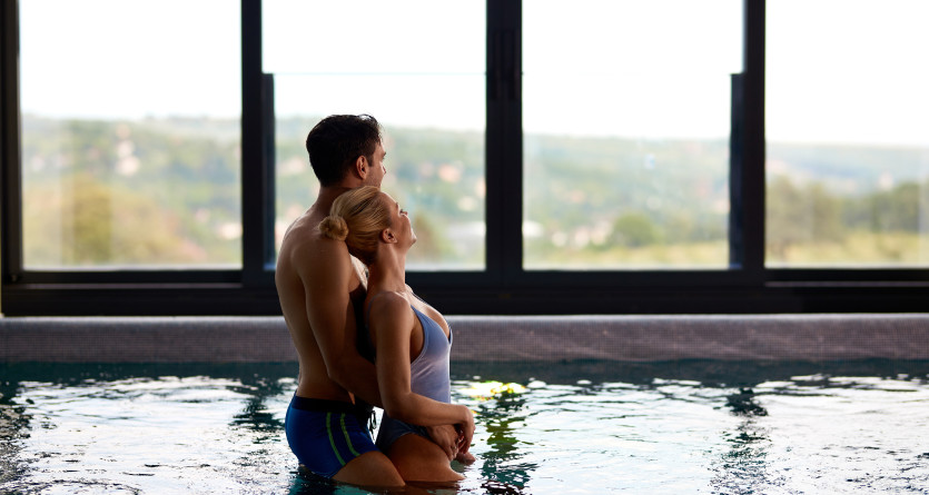 Couple enlac&eacute; dans un jacuzzi avec vue panoramique sur la campagne