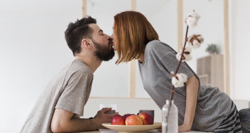 Couple partageant un baiser passionn&eacute; dans la cuisine