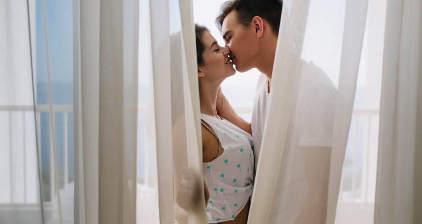 Couple s'embrassant derri&egrave;re un voilage