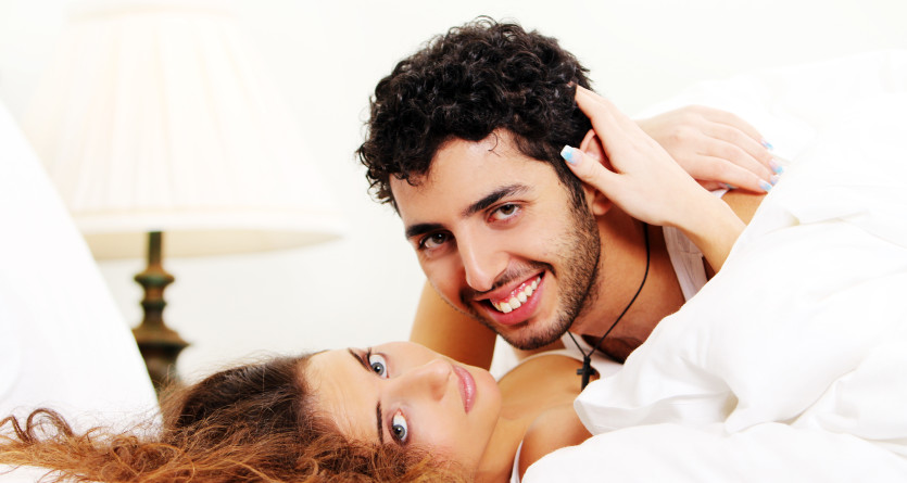 Couple joyeux partageant un moment tendre au lit