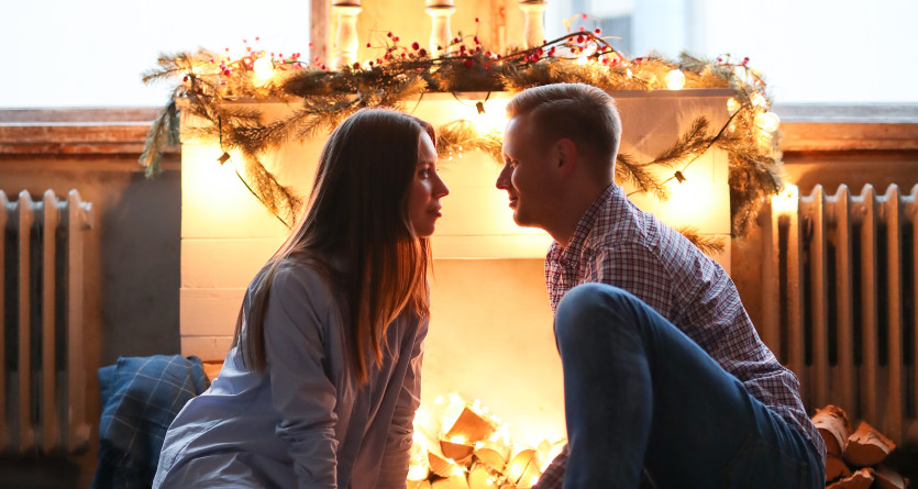 Couple romantique pr&egrave;s de la chemin&eacute;e dans une love room