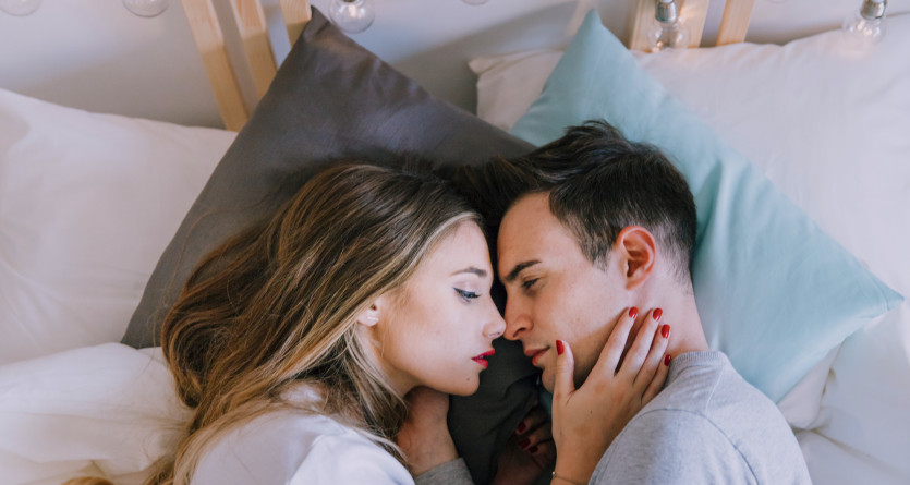 Couple allong&eacute; dans une chambre romantique, partageant un moment intime