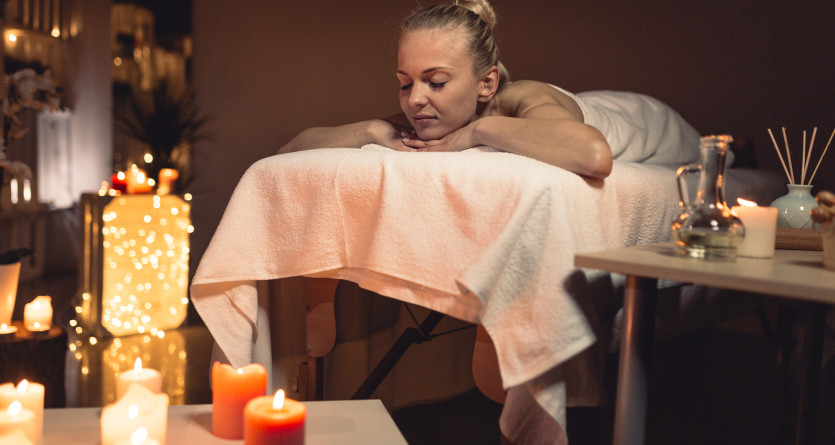 Femme se relaxant avec un massage dans une Love Room &eacute;clair&eacute;e par des bougies