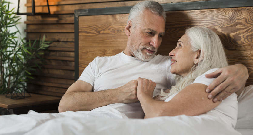 Couple mature se d&eacute;tendant dans une chambre romantique en bois