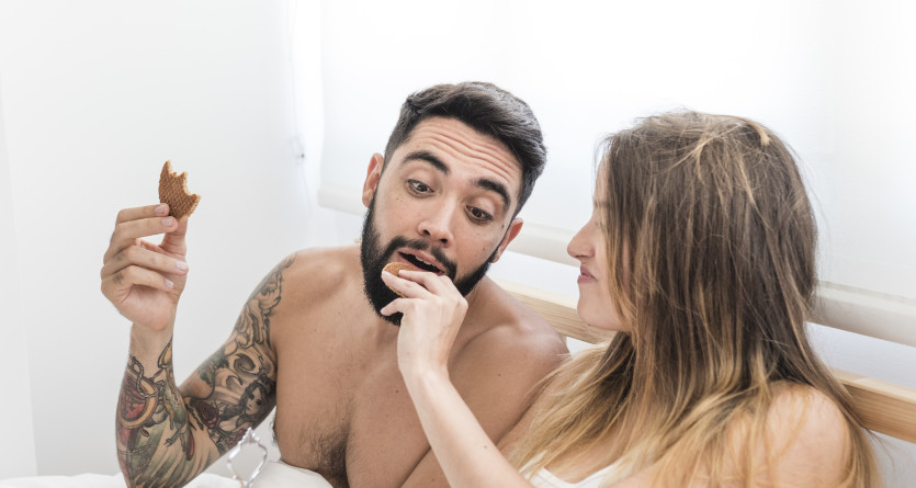 Couple savourant un petit-d&eacute;jeuner romantique au lit
