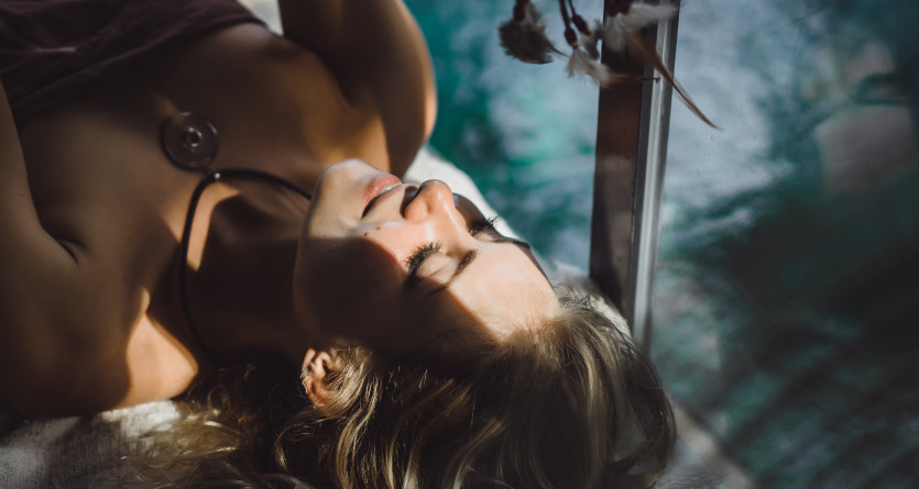 Femme se relaxant dans une love room, profitant de la lumi&egrave;re naturelle