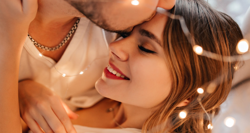 Couple partageant un moment de tendresse entour&eacute; de guirlandes lumineuses dans une Love Room