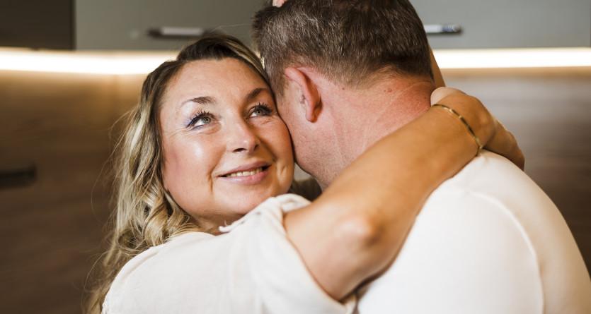 Couple partageant une &eacute;treinte tendre dans une ambiance chaleureuse et intime