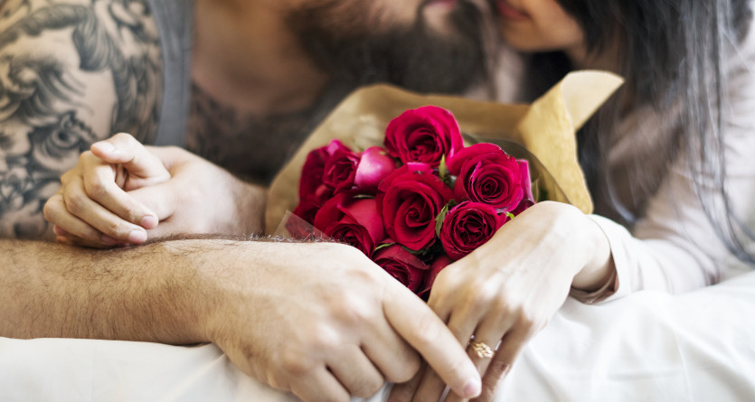 Couple amoureux avec bouquet de roses rouges dans une Secret Room